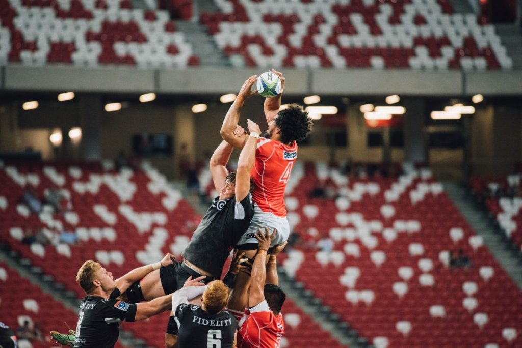 Men Jumping Up at Rugby Ball on a Rugby Pitch