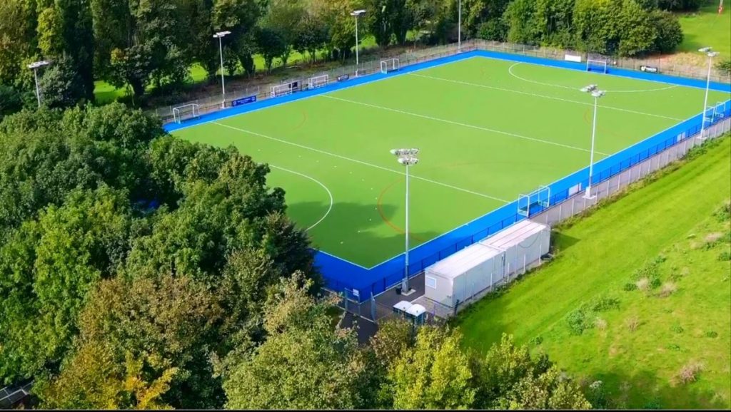 Aerial view of Barnes Hockey Club with trees and a light green hockey pitch