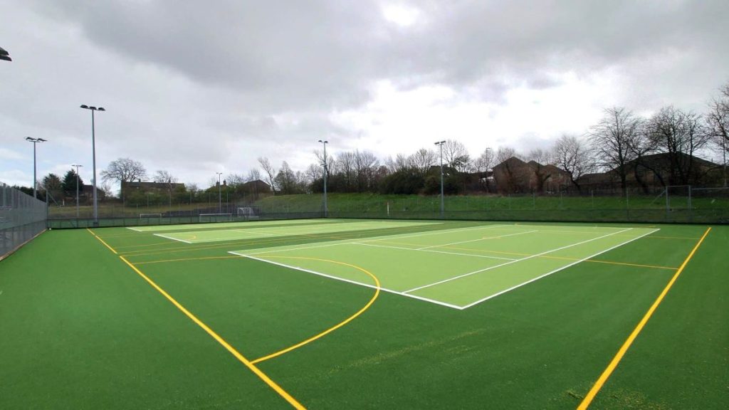 Tong School Multi Use Games Area. Green with yellow markers and grey skies.
