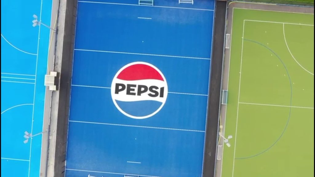 Aerial view of a blue hockey pitch with a Pepsi logo 'Pepsi Pitch' for Beeston Hockey Club in Nottingham installed by AS Sports